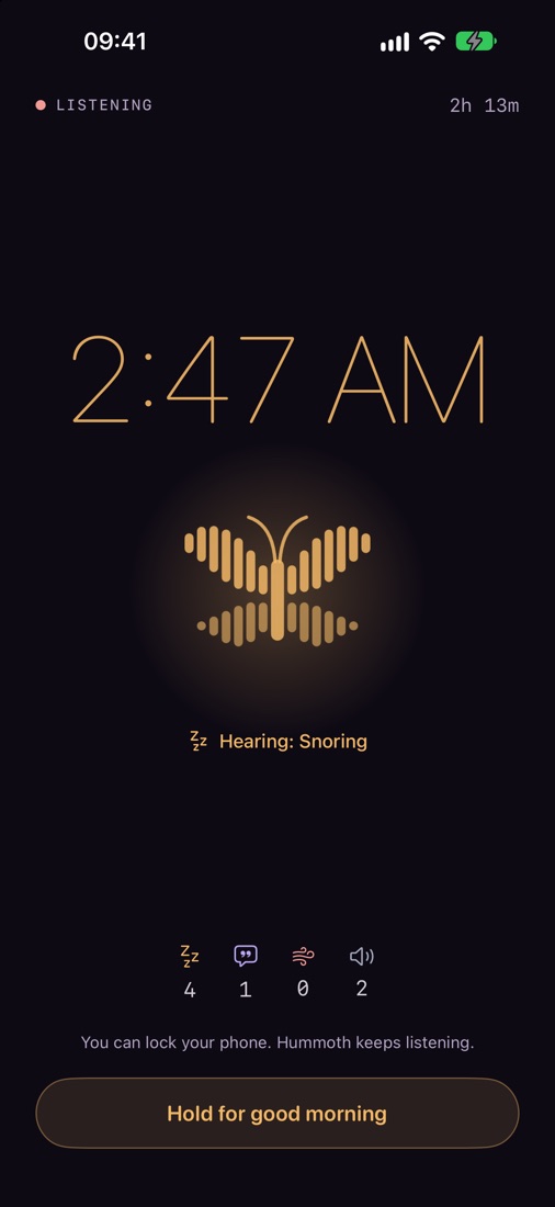 Bedside mode: a dim amber clock and the moth, listening